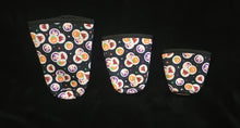 Load image into Gallery viewer, A set of three cup sleeves, in various sizes with the halloween sugar cookie pattern.