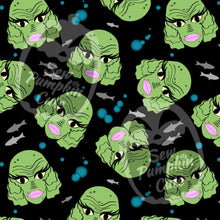 Load image into Gallery viewer, A Halloween-themed cartoonish pattern of a cutesy, green creature with lashes and pink lips. Blue bubbles and simple grey fish are in the back on a black background.