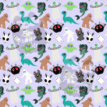 Load image into Gallery viewer, A cryptid-themed cartoonish pattern of mythical creatures, such as Bigfoot, Loch Ness Monster, Mothman, Aliens, Cthulhu, and more, on a periwinkle background.