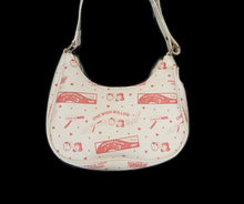 Load image into Gallery viewer, A white crescent-shaped shoulder bag with red cartoon illustrations from the ‘One Wish Willow' box
